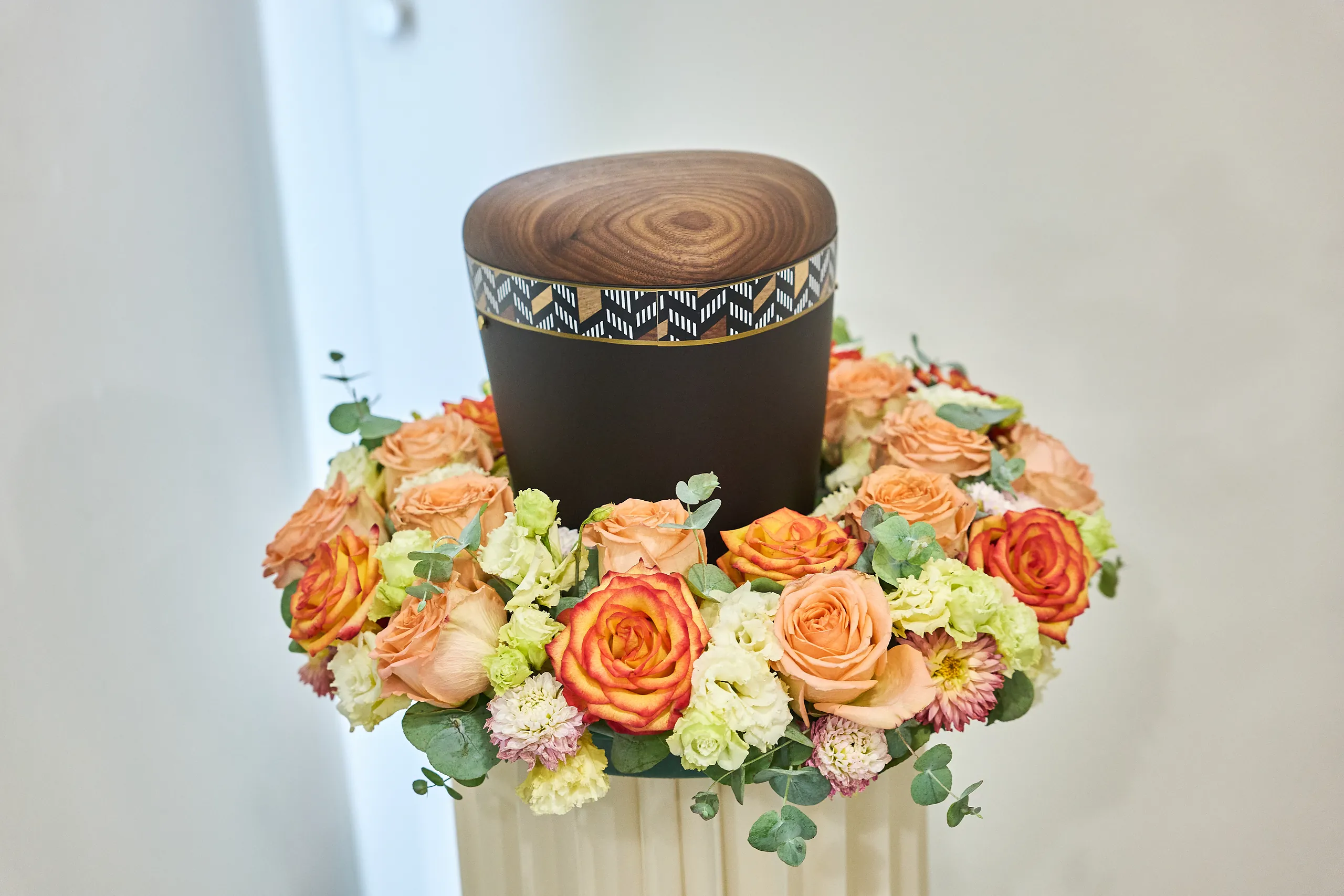 Holzurne mit Urnenkranz aus orangefarbenen Rosen von Spornraft Floristik